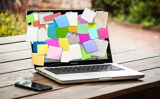 Symbolbild mit Laptop, auf dem Bildschirm kleben bunte Zettel
